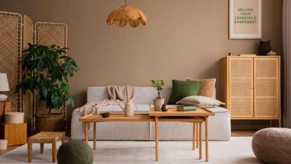 Image of a brown-toned living room. A sofa and a coffee table make up the centre of the image. In the top right-hand corner, a frame sits on the wall, in which a graphic print sits with the text 