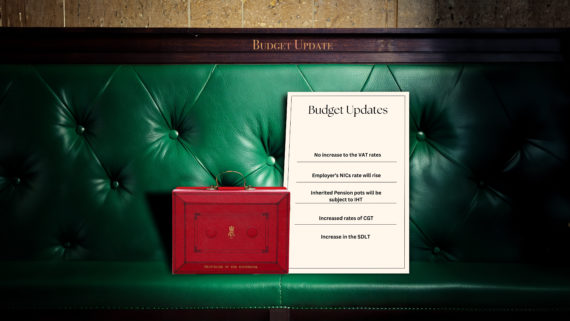 The red briefcase of the Chancellor of the Exchequer sits on a green House of Commons bench. Next to it stands a document that depicts the 5 key updates announced in the Autumn Budget. On the top of the bench, 'Budget Updates' is inscribed in gold.