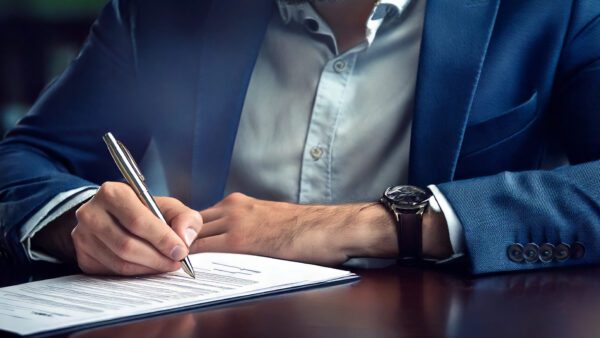 A man signing a Heads of Terms Contract